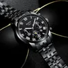 A close-up shot of a black men's watch with a metal band, set against a dark, reflective background with a gold accent. Produktbild-Vorschau