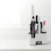A Shark StainForce cleaning device and spray bottle are displayed in a white charging dock on a white countertop. Podgląd zdjęcia produktu