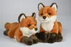 Two plush toy foxes are shown against a light gray background. One fox is lying down, and the other is sitting up. Produktbild-Vorschau