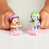 Two Bluey character toys on scooters, held by children's hands. Náhled obrázku produktu