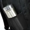 A close-up view of a silver metal water bottle or thermos placed in a black mesh side pocket of a backpack. Voir les images du produit