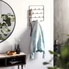A hallway vignette featuring a key holder with a jacket and keys, a round mirror, and a console table with decorative items. Produktbild-Vorschau