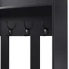 A close-up view of black coat hooks on a black shelf. Voir les images du produit
