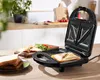 A sandwich maker is open on a kitchen counter, with sandwiches in various stages of preparation and completion. Produktbild-Vorschau