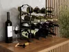 A wine rack filled with wine bottles on a wooden surface, with a single bottle and a wine glass in the foreground. Náhled obrázku produktu