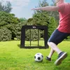 A man is kicking a soccer ball towards a rebounder net in a grassy yard with trees in the background. Voir les images du produit