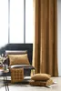A cozy corner with a chair and cushions, next to a large window and a curtain. Podgląd zdjęcia produktu