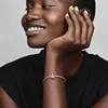 A close-up shot of a woman's face and arm, wearing a bracelet. Produktbild-Vorschau