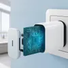A close-up of a white USB-C charger adapter plugged into a wall socket, with its internal circuit board exposed and glowing blue. Produktbild-Vorschau