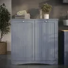 A grey laundry cabinet with two doors is shown in a room with a plant and folded towels on top. Produktbild-Vorschau