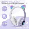 A pair of white and purple cat-ear wireless headphones with colorful LED lights on the ears and a paw print logo on the side. Text overlays highlight features like total duration, song capacity, and charging time. Produktbild-Vorschau