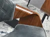 Close-up of a chair armrest, showing the texture of the fabric and the wood grain of the armrest. Náhled obrázku produktu
