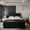 A bedroom with a large black upholstered bed as the main focus. Produktbild-Vorschau