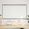 A white projection screen is mounted on a white wall above a light wood media console. The media console has a woven front and a small potted plant on top. A round rug is on the wooden floor in front of the console. Náhled obrázku produktu