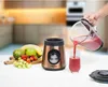 A hand is pouring a red smoothie from a blender pitcher into a glass, next to the blender base and a pile of fresh fruit. Voir les images du produit