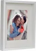 A framed photo of a couple, with the man kissing the woman's cheek while she holds an open red box. Produktbild-Vorschau