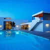 A modern house with a swimming pool at dusk. Produktbild-Vorschau