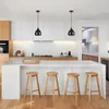 A modern kitchen with a white island, wooden stools, and black pendant lights. Náhled obrázku produktu