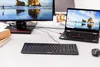 A black wired keyboard is placed on a white desk in front of a computer monitor and a laptop. Náhľad obrázku produktu