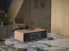 A compact stereo system is placed on a marble countertop in a modern living room setting. Produktbild-Vorschau