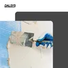 A hand wearing a blue and white glove is using a trowel to apply plaster to a wall, with a blue mesh visible. Produktbild-Vorschau