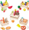 A collection of wooden toy food items arranged in crates and scattered around a white background. Náhľad obrázku produktu
