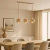 A dining room scene with a pendant light fixture over a wooden table and chairs. Produktbild-Vorschau