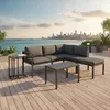 A sectional outdoor sofa set with a coffee table and side table on a wooden deck overlooking a city skyline and water. Produktbild-Vorschau