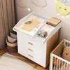 A nursery room with a changing table and a crib. Produktbild-Vorschau