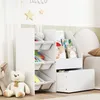 A white children's bookshelf with storage bins and books, placed in a nursery or playroom setting. Produktbild-Vorschau