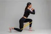 A woman performing a lunge exercise with a resistance band around her thighs. Produktbild-Vorschau