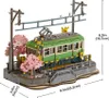 A 3D wooden model of a train station with a green train and cherry blossom trees. Produktbild-Vorschau