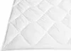 A close-up view of a white quilted blanket. Podgląd zdjęcia produktu