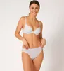 A woman is modeling a white bra and underwear set against a plain white background. Produktbild-Vorschau