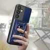 A hand holding a blue phone case with a ring holder, with a blurred background of a room. Produktbild-Vorschau