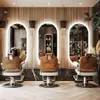 A modern barbershop interior with three illuminated oval mirrors and barber chairs. Podgląd zdjęcia produktu
