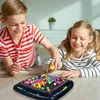 Two children are playing a board game with colorful marbles on the floor. Produktbild-Vorschau