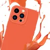 A close-up shot of an orange phone case with a splash of orange liquid around it. Produktbild-Vorschau