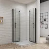 A shower enclosure with black frames and glass doors is shown in a bathroom setting with white brick walls and a wooden floor. Produktbild-Vorschau