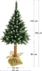 A decorated artificial Christmas tree with snow and pinecones, standing on a burlap base, with dimensions indicated by text overlays. Náhľad obrázku produktu