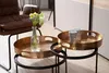A living room setting with two nested side tables, a brown leather chair, and a vase of flowers. Voir les images du produit