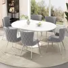 A dining set with an oval white table and six gray chairs, placed on a circular rug in a well-lit room with a large window overlooking a garden. Podgląd zdjęcia produktu