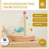 A wooden toy sailboat with a whale design on its sail, placed on a wooden surface with a tiled background. Anteprima dell’immagine prodotto