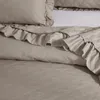 A close-up view of a taupe-colored bedspread with a diamond-stitched pattern and ruffled edges. Podgląd zdjęcia produktu