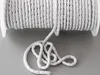 A roll of white weighted cord for curtains or drapes is shown on a gray surface. Produktbild-Vorschau