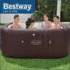 Four people relaxing in a brown inflatable hot tub on a grassy lawn. Produktbild-Vorschau