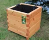 A wooden planter box sits on grass with a tree in the background. Produktbild-Vorschau