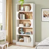 A white bookshelf filled with books and decorative items, placed in a room with a window and curtains. Produktbild-Vorschau