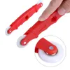A hand is holding a red spline roller tool with a white wheel, with another tool in the background. Produktbild-Vorschau