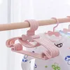 A stack of pink baby hangers with bow details hanging on a wooden rod. Produktbild-Vorschau